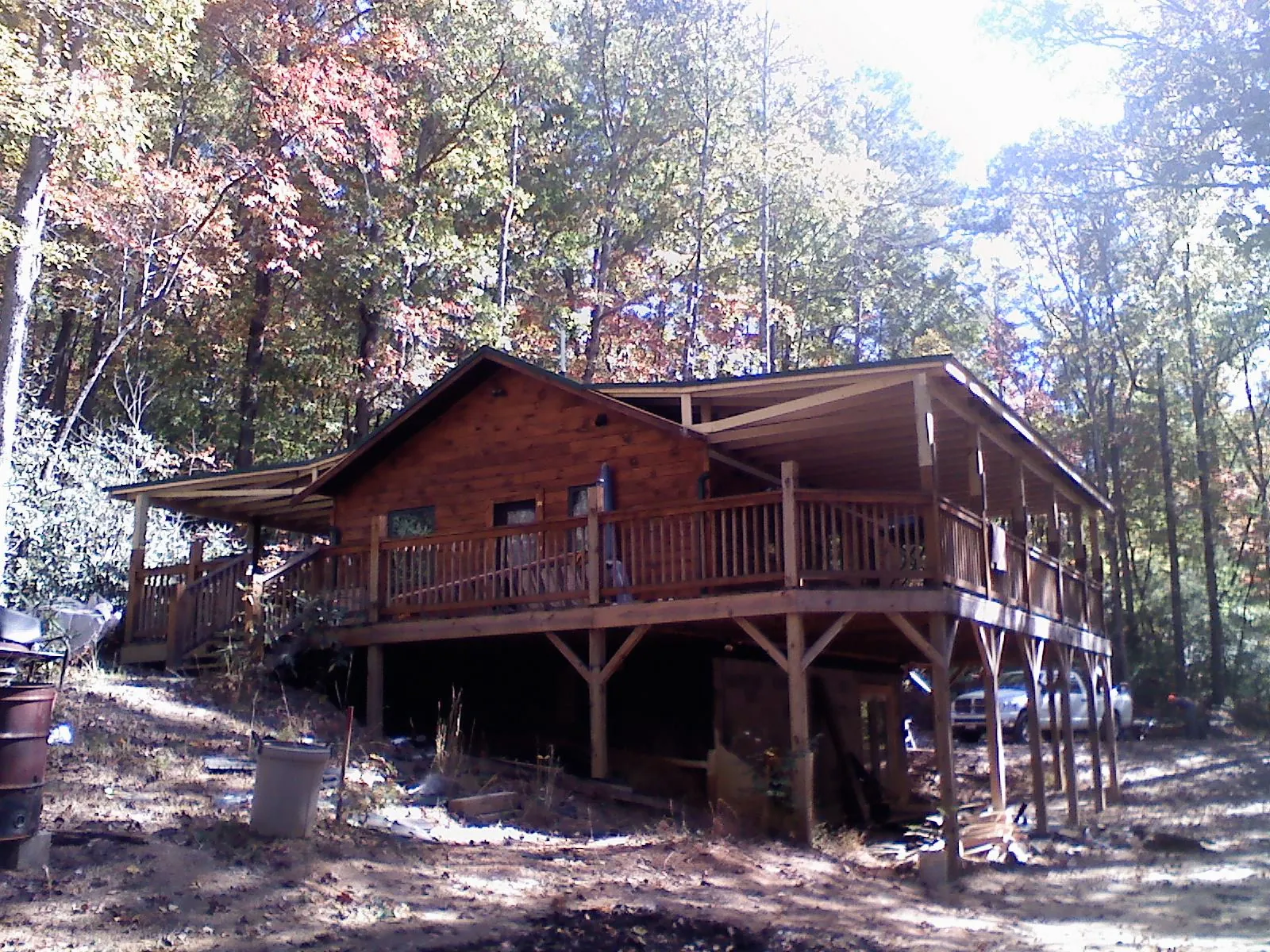 Log cabin with a wraparound porch and metal roof in the fall in Geneva